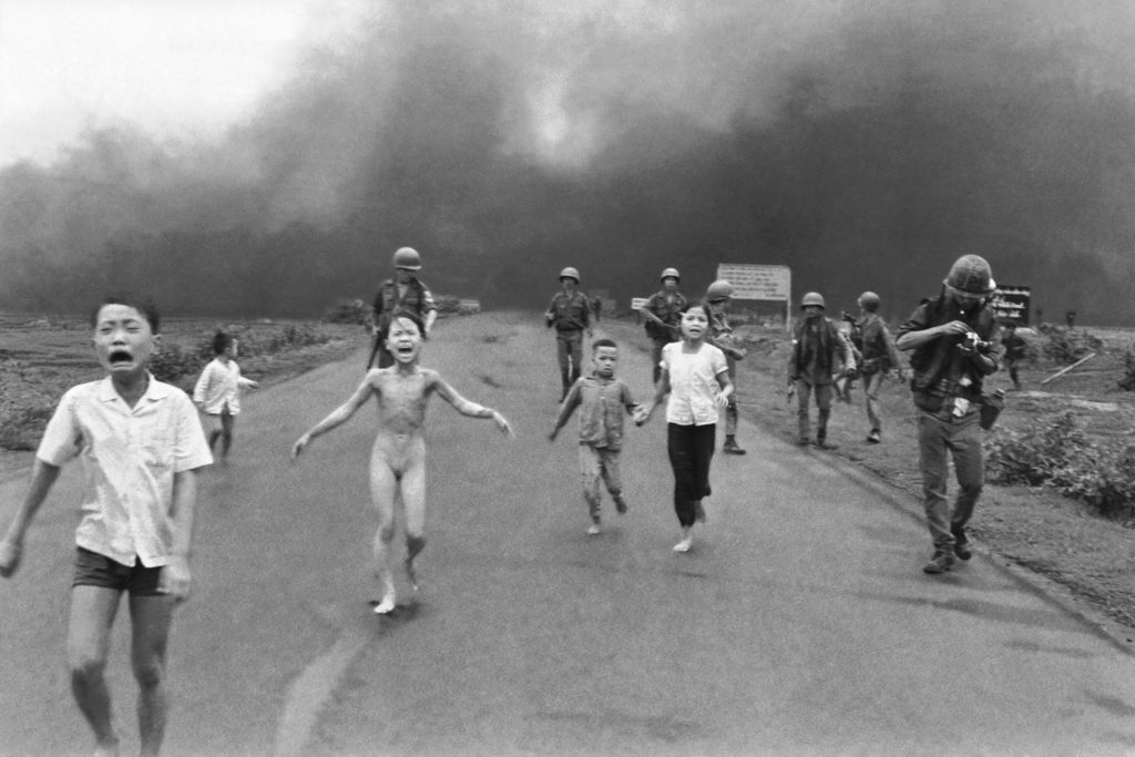 South Vietnamese forces follow after terrified children, including 9-year-old Kim Phuc, center, as they run down Route 1 near Trang Bang after an aerial napalm attack on suspected Viet Cong hiding places, June 8, 1972. A South Vietnamese plane accidentally dropped its flaming napalm on South Vietnamese troops and civilians. The terrified girl had ripped off her burning clothes while fleeing. The children from left to right are: Phan Thanh Tam, younger brother of Kim Phuc, who lost an eye, Phan Thanh Phouc, youngest brother of Kim Phuc, Kim Phuc, and Kim's cousins Ho Van Bon, and Ho Thi Ting. Behind them are soldiers of the Vietnam Army 25th Division.